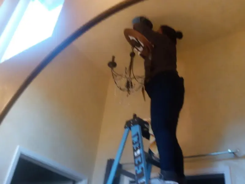 Electrician installing a chandelier in a Twinsburg residence